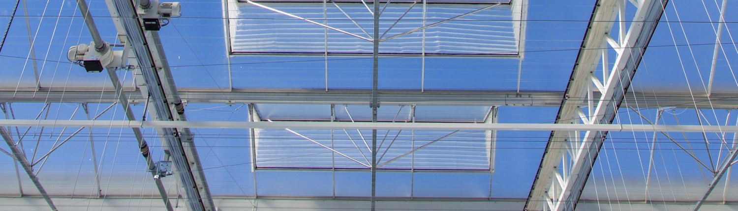 Kasdak van onderaf gezien met glazen panelen, stalen constructie en motoren voor dakramen